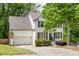 Charming two-story home with a white brick exterior, well-manicured landscaping, and attached two-car garage at 6000 Hampton Bluff Way, Roswell, GA 30075