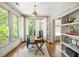 Bright home office featuring hardwood floors, large windows providing natural light, and custom built-in bookshelves at 6000 Hampton Bluff Way, Roswell, GA 30075