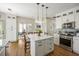 Well-lit kitchen featuring white cabinets, stainless steel appliances, an island with seating, and hardwood flooring at 6000 Hampton Bluff Way, Roswell, GA 30075