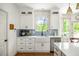 Bright kitchen features white cabinets, stainless steel appliances, and a farmhouse sink at 6000 Hampton Bluff Way, Roswell, GA 30075