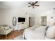 Bright bedroom boasts a ceiling fan, wood floors, and an ensuite bathroom with double vanity at 6000 Hampton Bluff Way, Roswell, GA 30075