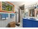 Bathroom featuring blue vanity, natural light, and unique patterned wallpaper at 6525 Old Riverside Nw Dr, Sandy Springs, GA 30328