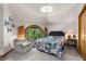 Cozy bedroom with a circular window overlooking a lush, green view, and a decorative patterned bedspread at 6525 Old Riverside Nw Dr, Sandy Springs, GA 30328