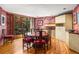 Elegant dining room featuring a round table, hardwood floors, and serene backyard views through a large picture window at 6525 Old Riverside Nw Dr, Sandy Springs, GA 30328