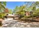 House exterior with multi-car garage, mature trees, and lush surroundings at 6525 Old Riverside Nw Dr, Sandy Springs, GA 30328