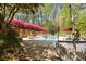 Backyard pool and deck area offering a private oasis with beautiful landscaping and a stone retaining wall with flowering shrubs at 6525 Old Riverside Nw Dr, Sandy Springs, GA 30328