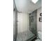 Modern tiled shower with a glass door, showcasing a pebble floor and updated fixtures at 1261 Lavista Rd # N4, Atlanta, GA 30324