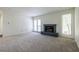 Sunlit living room featuring modern gray carpeting, a fireplace, and French doors at 223 Tuxworth Cir, Decatur, GA 30033