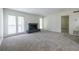 Open living room featuring neutral carpet, a brick fireplace, and bright, natural light at 223 Tuxworth Cir, Decatur, GA 30033