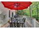 Back deck with a red umbrella and table, overlooking the backyard's natural setting at 2973 Misty Rock Cv, Dacula, GA 30019