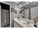Gray bathroom with double sink vanity, large mirror, decorative art, and a shower with curtain at 2973 Misty Rock Cv, Dacula, GA 30019