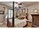 Comfortable bedroom featuring a four-poster bed, ceiling fan, and natural light from the window at 2973 Misty Rock Cv, Dacula, GA 30019