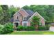 Charming two-story brick home with a manicured lawn and mature landscaping at 2973 Misty Rock Cv, Dacula, GA 30019