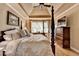 Comfortable main bedroom with tray ceiling, hardwood floors, a four poster bed and ample light at 2973 Misty Rock Cv, Dacula, GA 30019