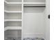 Walk-in closet featuring built-in shelving, a hanging rod, and custom tiling at 4327 Wellington Hills Ln, Snellville, GA 30039