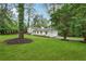 Landscaped home exterior with a large green lawn and long driveway leading to a garage at 4327 Wellington Hills Ln, Snellville, GA 30039