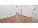 Hallway leading to a bathroom, featuring neutral paint, white trim, and luxury vinyl plank flooring at 4327 Wellington Hills Ln, Snellville, GA 30039