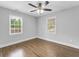 Bedroom with hardwood floors, ceiling fan, and windows overlooking the backyard at 5438 Hiram Lithia Springs Rd, Powder Springs, GA 30127