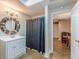 Bathroom featuring a modern vanity, decorative mirror, shower with curtain, and calming colors for a refreshing experience at 9465 Grande Dr, Winston, GA 30187