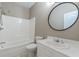 Bright bathroom showcasing a sleek vanity, a modern round mirror, and a shower-tub combination at 9465 Grande Dr, Winston, GA 30187
