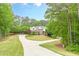 Beautiful home with a circular driveway and lush trees surrounding the well-manicured lawn at 9465 Grande Dr, Winston, GA 30187
