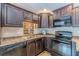 Cozy kitchen features dark wood cabinets, speckled countertops, and modern appliances at 9465 Grande Dr, Winston, GA 30187