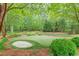 Backyard putting green with surrounding lush landscape and adjacent sand trap at 9465 Grande Dr, Winston, GA 30187
