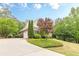 Side view of a well-maintained brick home with manicured lawns and mature trees around property at 9465 Grande Dr, Winston, GA 30187