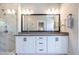 A double sink vanity in the bathroom includes a frameless mirror and a tiled shower at 834 S Columbia Dr, Decatur, GA 30030