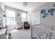Bright Bedroom featuring a crib, dresser, and a cozy armchair, creating a comfortable space at 834 S Columbia Dr, Decatur, GA 30030