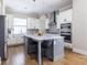Modern kitchen with stainless steel appliances, gray island, pendant lights, and decorative tile backsplash at 834 S Columbia Dr, Decatur, GA 30030