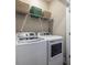 Convenient laundry room featuring a modern washer and dryer set, with upper shelving for storage solutions at 834 S Columbia Dr, Decatur, GA 30030