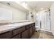Bright bathroom featuring a double sink vanity, glass shower door, and neutral tile flooring at 111 Centennial Ridge Dr, Acworth, GA 30102