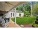 Well-manicured backyard with a covered porch, rocking chairs, and lush green lawn, perfect for outdoor living at 141 Springbrooke Trl, Dallas, GA 30157