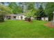 Expansive backyard with manicured lawn, mature trees, and a charming home exterior at 141 Springbrooke Trl, Dallas, GA 30157