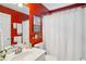 Bright bathroom with red accent wall features a shower and sink with matching fixtures at 141 Springbrooke Trl, Dallas, GA 30157