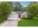 Charming single-story home features a well-maintained lawn, a two-car garage, and a bright red front door at 141 Springbrooke Trl, Dallas, GA 30157