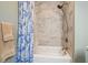 Shower-tub combination with a nautical-themed shower curtain and marble-style tile at 2801 Holly Oaks Dr, Marietta, GA 30062