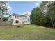 Expansive backyard with lush lawn, wooden fence, and mature trees at 310 Bloomfield Ct, Roswell, GA 30075