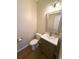 Half bath with white fixtures and a light wood-framed mirror at 310 Bloomfield Ct, Roswell, GA 30075