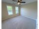 Neutral bedroom with a ceiling fan and two windows at 310 Bloomfield Ct, Roswell, GA 30075