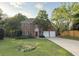 Charming brick two-story home with well-manicured lawn and a long driveway leading to a two-car garage at 310 Bloomfield Ct, Roswell, GA 30075