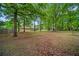 Large, wooded backyard with a view of the home, providing a serene and natural setting at 110 Otelia Ln, Covington, GA 30014