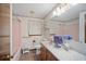 Bathroom featuring pink fixtures, marble countertops, and a tub with shower at 110 Otelia Ln, Covington, GA 30014