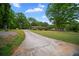 Long paved driveway leading to a charming brick home with mature trees at 110 Otelia Ln, Covington, GA 30014