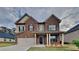 Charming brick two-story home boasts a covered porch, two-car garage, and manicured lawn at 245 Brickstone Pkwy, Covington, GA 30016