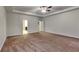Large main bedroom with tray ceilings, ceiling fan, and access to an en-suite bathroom at 245 Brickstone Pkwy, Covington, GA 30016