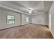 Spacious main bedroom featuring plush carpet, tray ceiling with fan, and large windows at 245 Brickstone Pkwy, Covington, GA 30016