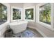 Bright bathroom featuring a freestanding tub positioned between two windows, creating a serene and relaxing ambiance at 2490 Turtle Ter, Grayson, GA 30017
