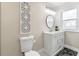 Elegant bathroom featuring a modern vanity with marble countertop, a stylish round mirror, and decorative wall art at 2490 Turtle Ter, Grayson, GA 30017